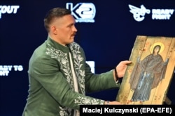 Олександр Усик тримає ікону під час пресконференції у Вроцлаві, Польща, 24 серпня 2023 року