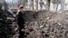 Un bărbat din Avdiivka analizează un crater apărut recent, după ce rușii au bombardat centrul orașului. 