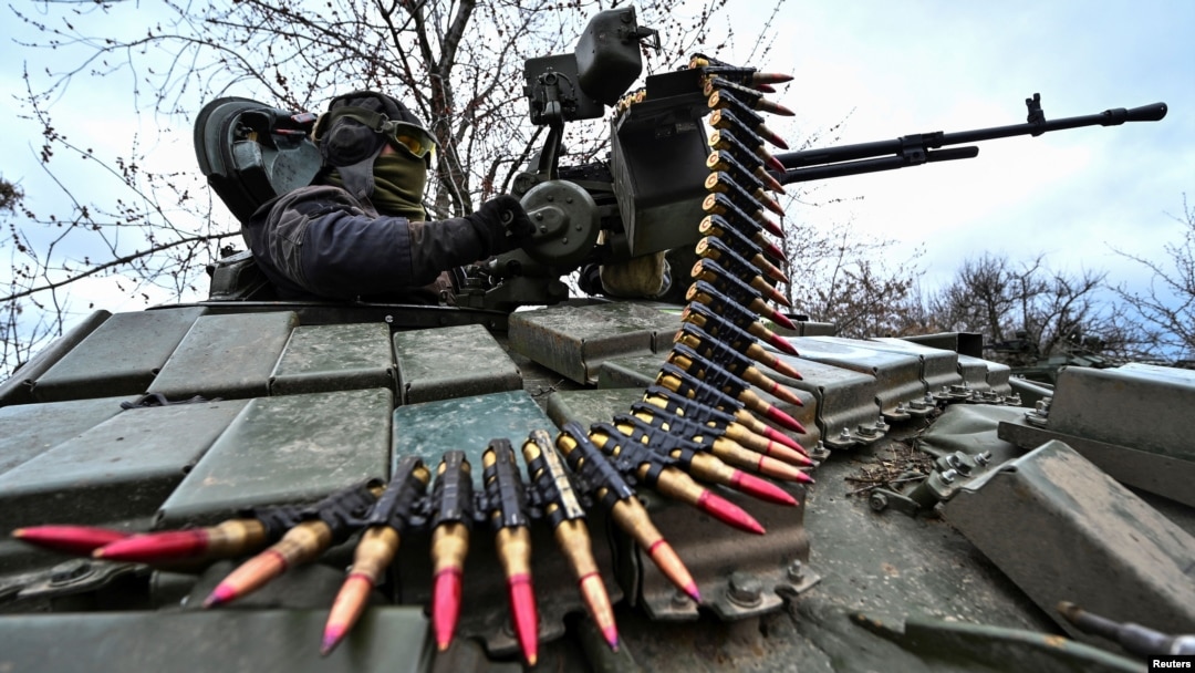 Украински военнослужещ зарежда боеприпаси за картечница по време на военно учение близо до фронтовата линия, 29 март 2023 г.