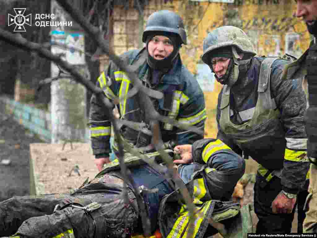 Рятувальники виносять пораненого колегу з місця ракетного обстрілу в Одесі.15 березня 2024 року.&nbsp; Рятувальники, які прибули на місце російського ракетного удару в Одесі, де розпочалася пожежа, загинули внаслідок другого ракетного удару, завданого Росією по тому самому місці. За словами офіційних осіб, серед щонайменше двох десятків загиблих через російську ракетну атаку вдень 15 березня &ndash; були цивільні,&nbsp; фельдшер і рятувальник ДСНС.