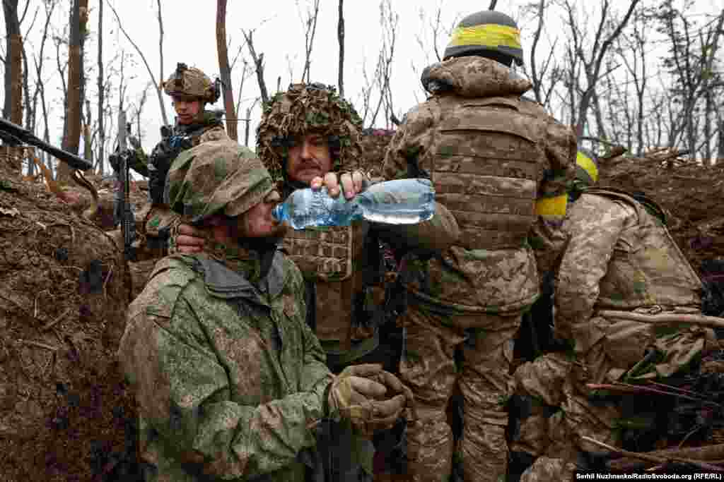 Расейскаму вайскоўцу даюць ваду пасьля яго захопу ўкраінскімі войскамі непадалёк ад Бахмуту, травень 2023&nbsp; 