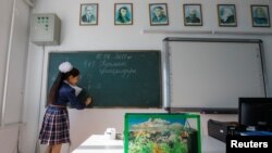 Школьница решает задачу на уроке химии в средней школе села в Кызылординской области