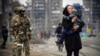Цивільні поруч із російськими солдатами під час захоплення арією РФ Маріуполя. 12 квітня 2022 року