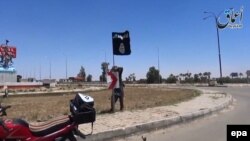 Иракъ -- Рамади гIалахь Исламан пачхьалкх олучу тобанан байракх дIатухуш ву вевзаш воцу стаг, Стиг. 18, 2015