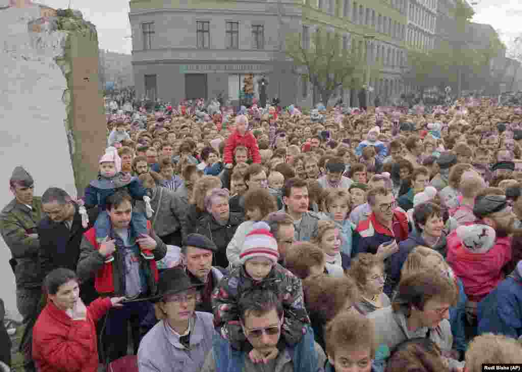 Un val de oameni trecând printr-o spărtură a Zidului pe 11 noiembrie 1989, după ce soldaților est-germani și s-a ordonat să se dea la o parte și să lase berliezii din est să treacă. Puțini treceau și dinspre vest spre est, ca să își ia rudele. Era sfârșitul divizării Berlinului. Era începutul sfârșitului pentru divizarea Europei.&nbsp; În urma negocierilor dintre Moscova, Washington, Londra, Paris, Berlin (Germania ex-comunistă) și Bonn (Germania Federală), statul german va fi, la rândul său, reunificat, pe 3 octombrie 1990.&nbsp;
