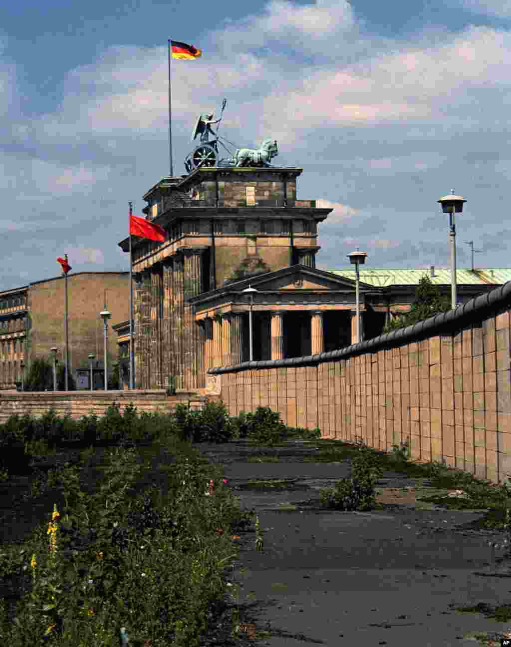 Imagine dinspre partea de vest: Zidul Berlinului, în august 1974. În fundal se vede Poarta Brandenburg, monument iconic al Europei. Poarta a fost blocată de Zid pentru aproape trei decenii (1961-1989).&nbsp;