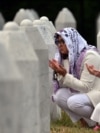 Боснийские мусульманки молятся у могил своих родственников на мемориальном кладбище в Сребренице