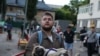 Locuitorii din Kiev au ieșit în fața unei case avariate de un atac aerian rus, în dimineața zilei de 6 iunie 2025.<br><br>Unul dintre localnici își ține câinele în brațe. Animalele sunt și ele foarte afectate de explozii.