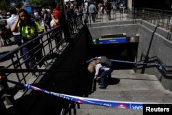 Un lucrător de la metrou trece pe sub bandă pentru a intra în stația de metrou Legazpi, după ce metroul a fost închis