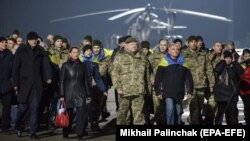 Президент України Петро Порошенко (посередині) разом зі звільненими з полону українцями, яких утримували російські гібридні сили на окупованій частині Донбасу. Харків, 27 грудня 2017 року