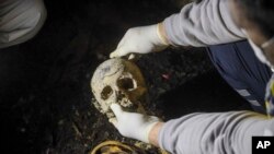 Супрацоўнік сырыйскай грамадзянскай абароны аглядае чалавечыя парэшткі, знойдзеныя ў двух падвалах на ўскраіне Дамаску 28 студзеня 2025 году. Паводле зьвестак «Белых касак», абгарэлыя парэшткі тут належаць прынамсі 26 ахвярам рэжыму Башара Асада