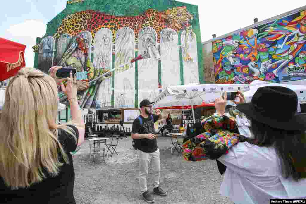 Valentin Dobrin oferă turiștilor explicații în cadrul evenimentului &bdquo;Alternative Bucharest Tour&rdquo;. În cadrul turului sunt explorate zonele de artă stradală, picturile murale, graffiti și arhitectura din București.