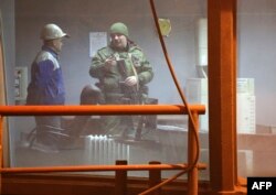Militar independentist vorbește cu un muncitor la usina metalurgică Uzov din Donețk, 1 martie, 2017