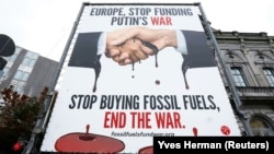 Un panou publicitar pe care scrie „Europa, nu mai finanța războiul lui Putin. Nu mai cumpărați combustibili fosili, puneți capăt războiului”, afișat în 2022 în fața Parlamentului European din Bruxelles.