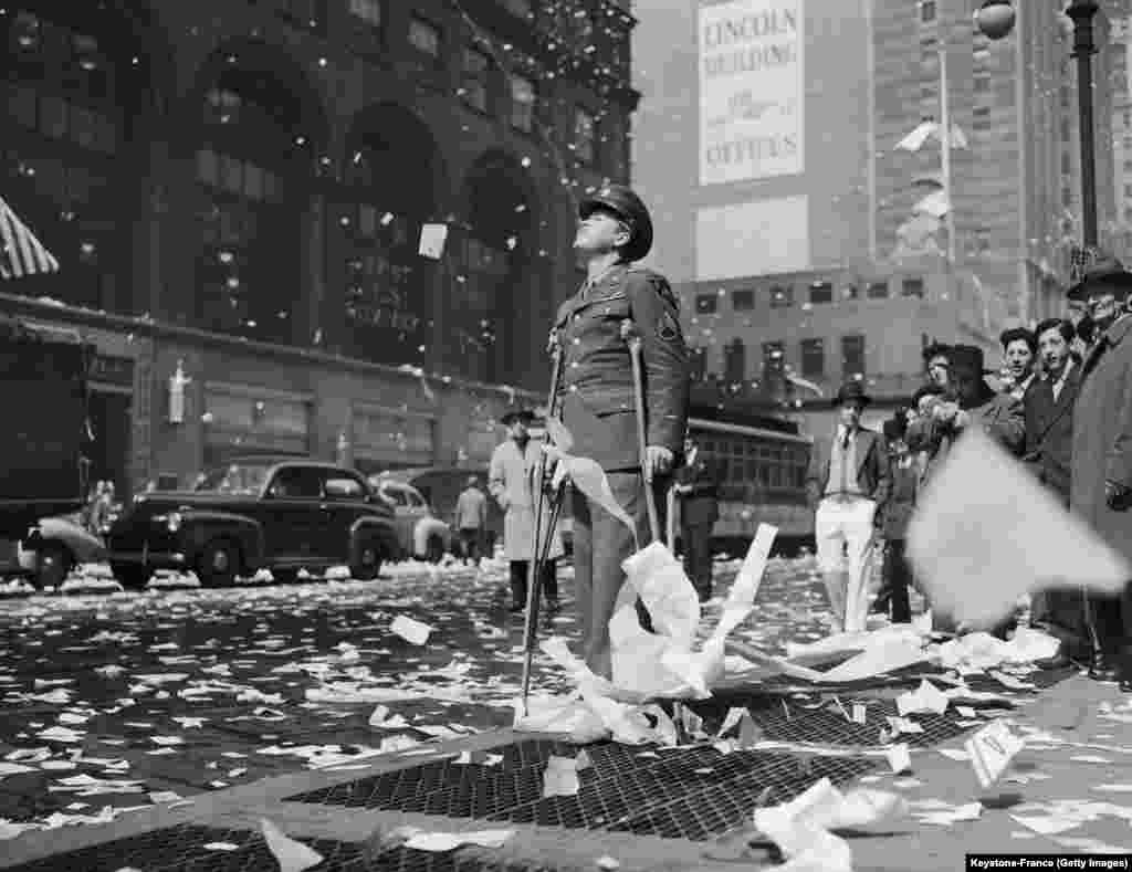 New York City, Statele Unite ale Americii, 8 mai 1945 - Sergentul american rănit Arthur Moore în euforia generală de pe strada 42. Sfârșitul războiului tocmai fusese declarat.