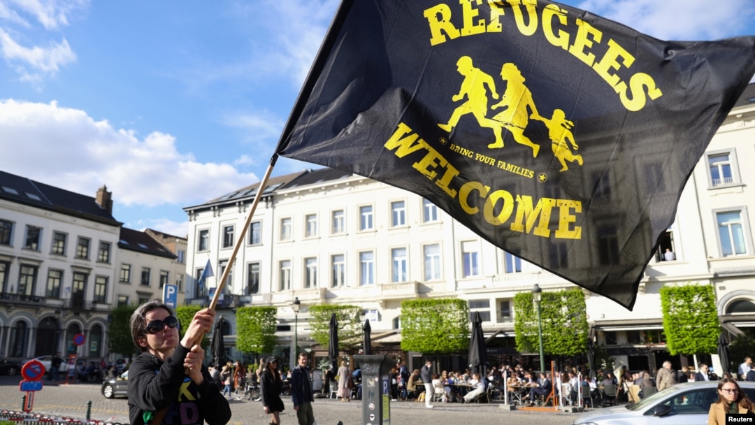 Žena maše zastavom u znak protesta ispred Evropskog parlamenta uoči glasanja o reformi politike azila i migracija, Brisel, 10. april 2024.