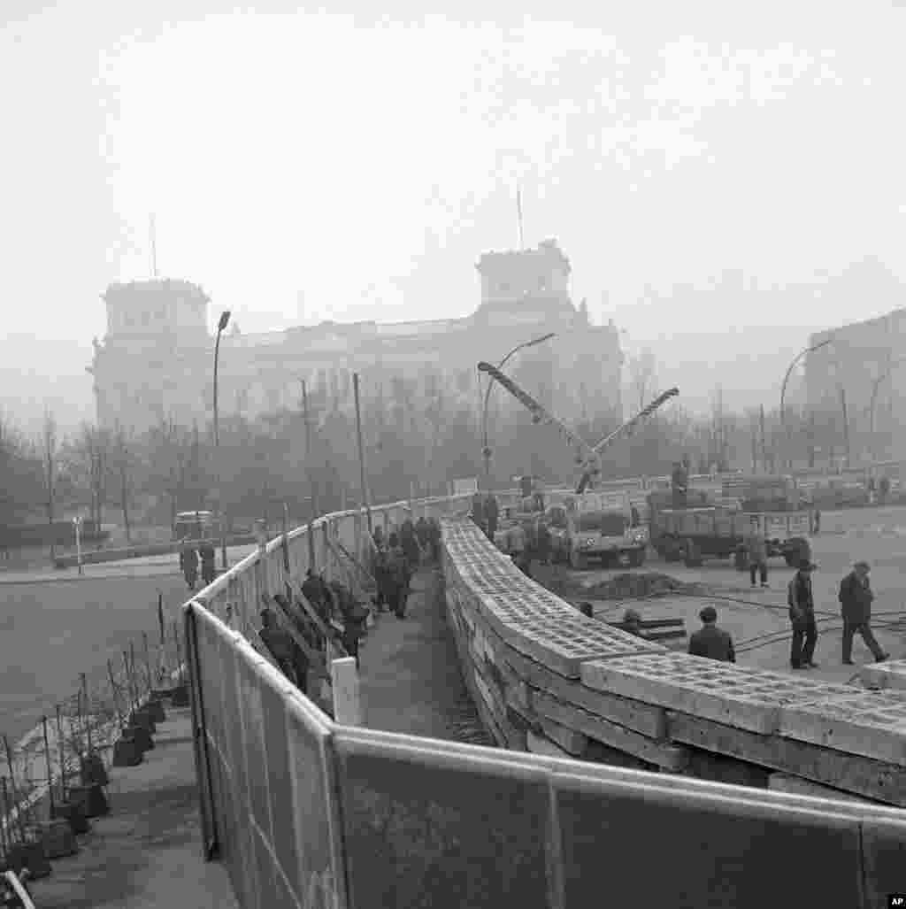 Soldați est-germani care au lucrat la ridicarea Zidului Berlinului în apropiere de clădirea Reichtag-ului/ Parlamentului, în noiembrie 1961.&nbsp;