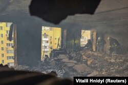 Пожарные работают внутри жилого дома, пострадавшего от удара российского беспилотника, Харьков, 7 июня 2025 года