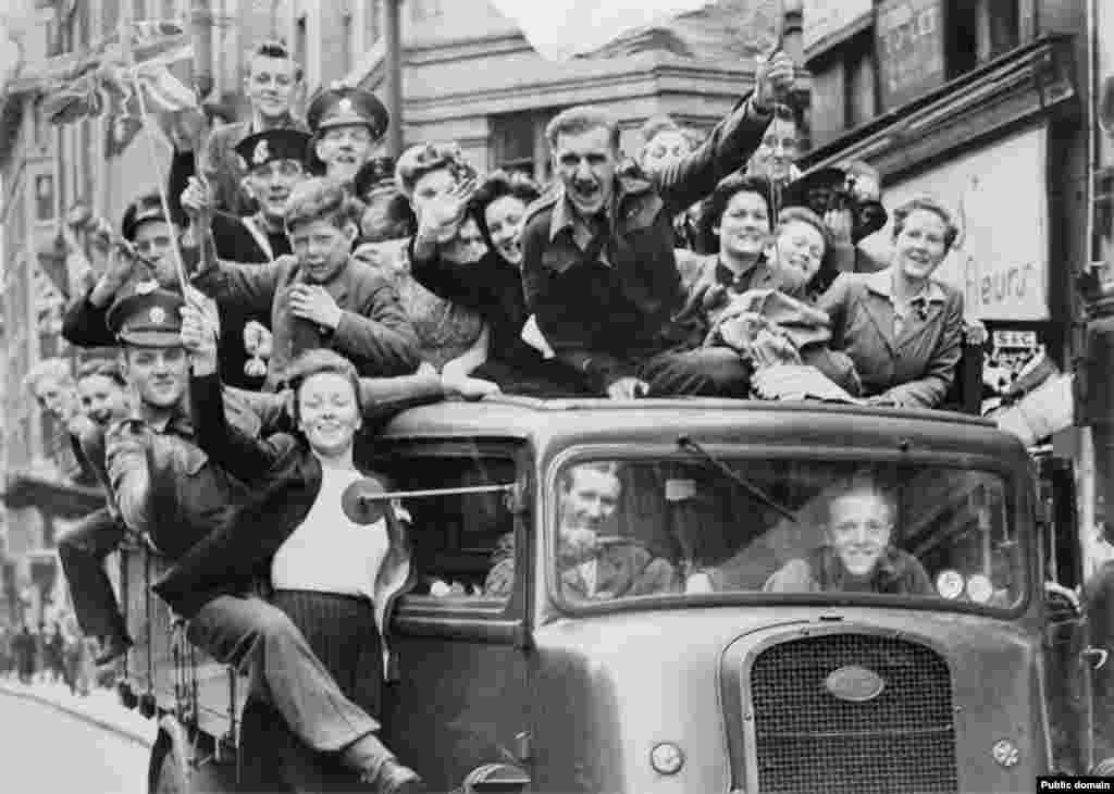 Londra, Marea Britanie, 8 mai 1045 - O camionetă aglomerată traversează capitala. Un martor ocular al sărbătorilor descrie atmosfera ca fiind „contagioasă” și spune că bucuria „a izbucnit spontan în fiecare membru al fiecărei familii, de la cei mai mici bebeluși până la cele mai în vârstă cupluri care se țin de mână și poartă pălării de hârtie în roșu, alb și albastru”.