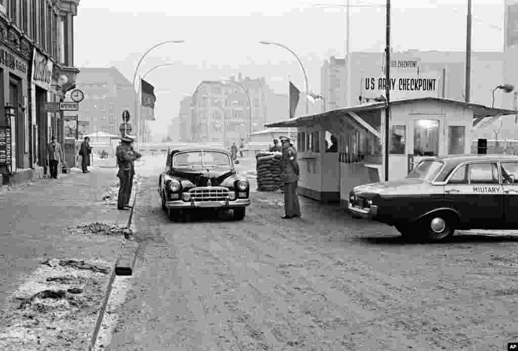 O mașină trece din estul în vestul Berlinului printr-unul dintre puncte de control al frontierei, Checkpoint Charlie, administrat de trupele americane, în octombrie 1964. Checkpoint Charlie este acum un punct cheie pentru turiștii interesați de istorie.