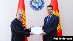 Түркиянын элчиси Мекин Мустафа Кемал Өкем (солдо) Кыргызстандын тышкы иштер министринин орун басары Медер Абакировго ишеним грамотасын тапшырып жатат. Бишкек. 7-апрель, 2025-жыл. 